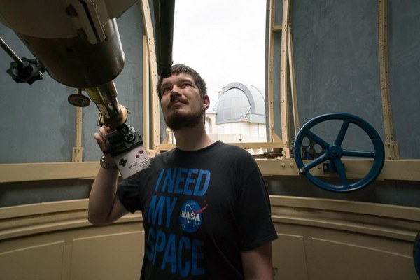 Alex looking through a telescope